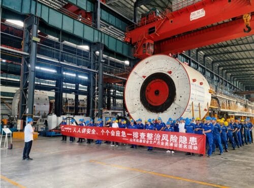 Sunward employees take part in safety production month activities beside shield machine equipment in the workshop
