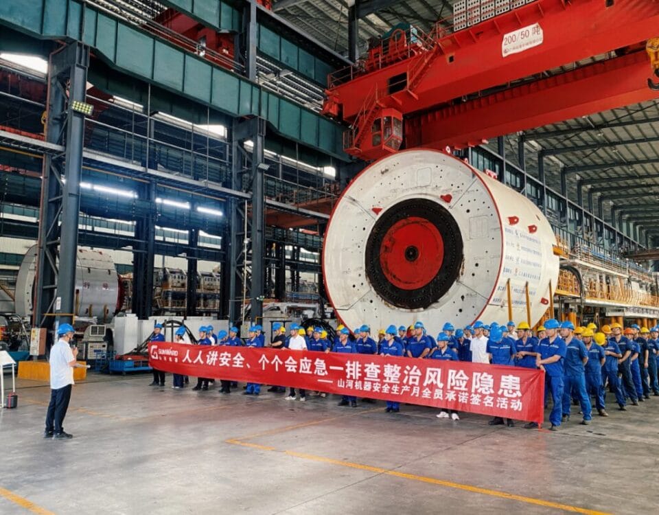 Sunward employees take part in safety production month activities beside shield machine equipment in the workshop